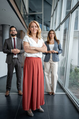Confident businesswoman leading team in modern office building