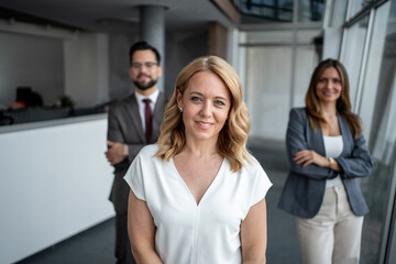Successful businesswoman smiling with her team in modern office