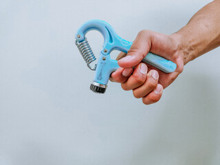 Man using hand exerciser to build grip strength. 
