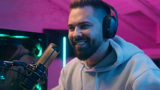 Caucasian millennial guy male gamer man streamer blogger vlogger influencer radio presenter in headphones studio streaming computer online video gaming cyber sport addict happy win achieve success