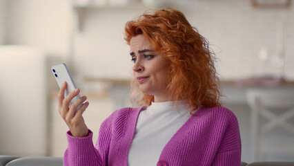 Caucasian woman lady user female girl at home couch indoor using telephone application looking at...