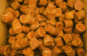 Close-up shot of jaggery pieces in a box, Bangalore, India.  The composition showcases texture and...