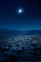 Christmas star over frozen ground and rocky terrain at night. Nativity theme.  
