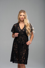 Attractive blonde woman wearing lingerie posing sensually in minimalistic studio setup