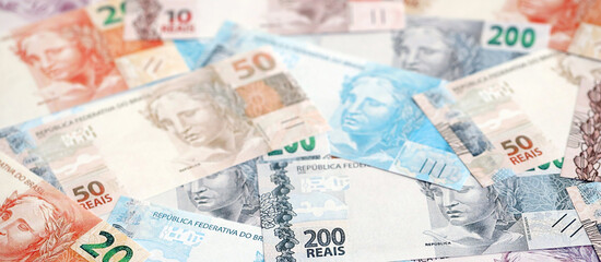Brazilian reais banknotes. The current Brazil real money bills lies on table in big amount