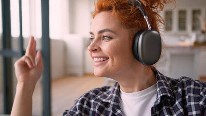 Happy smiling relaxing Caucasian woman female girl lady enjoying listening music in wireless...