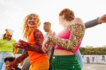 Happy young people dancing outdoor at festival event - Party, summer and entertainment concept - Focus on right girl shoulder