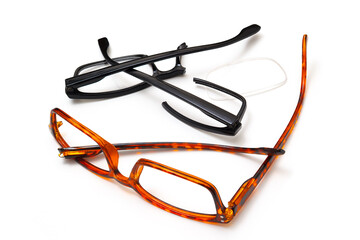 Two pairs of broken eyeglasses on white
