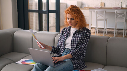 Caucasian woman lady at couch sofa busy at home girl female homeowner using laptop online internet...