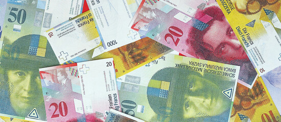 Swiss franc banknotes. The current francs money bills lies on table in big amount