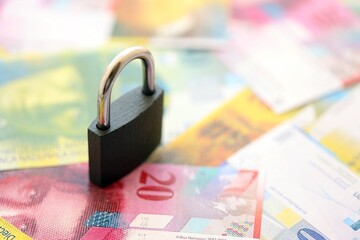 Swiss franc banknotes and padlock. The current francs money bills with lock lies in big amount