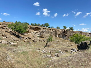 Landscape of stone hills along the banks of the Moskovka river on which green steppe vegetation stubbornly breaks through under the bright rays of the sun. © Hennadii