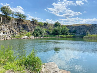 Panorama of impregnable stone cliffs surrounding the steppe lake, on which steppe vegetation breaks...