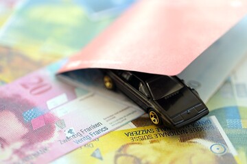 Swiss franc banknotes and toy car with passport. The current francs money bills and car with pass
