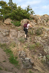 Fototapeta premium female tourist walking with backpack on beach and rocks