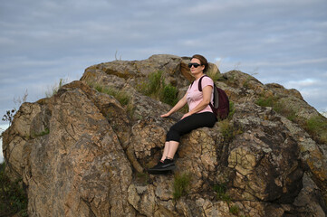 female tourist walking with backpack on beach and rocks