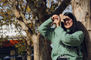 playing with a dry autumn leaf in the square