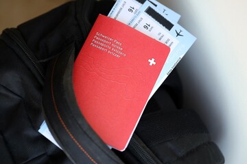 Swiss passport and avia tickets on travel bag. Pass and boarding tokens on bag close up