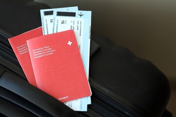Swiss passport and avia tickets on travel bag. Pass and boarding tokens on bag close up
