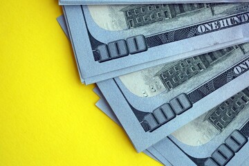 Big amount of United States hundred dollar bills on yellow background