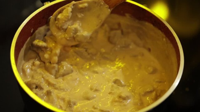 Strogonoff de Carne com creme de leite em panela sendo preparada em cozinha de casa de vov&oacute;. 
