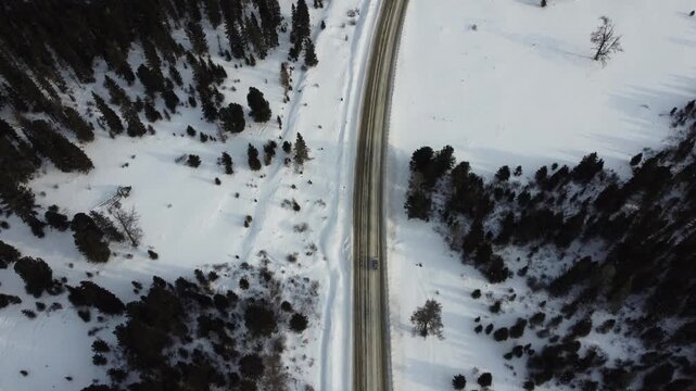Aerial footage of a winding snow-covered road leading to Ust-Koksa in the Altai Republic, Russia. The video shows scenic winter landscapes with forests, hill