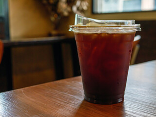Iced americano black coffee on a wooden desk in coffee shop