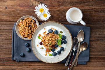 Granola with yogurt and blueberries, table top view. Healthy breakfast meal