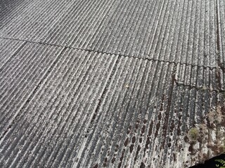 Fototapeta premium Old asbestos cement roofing sheets with rainwater drainage, asbestos roof, corrugated asbestos cement roof sheet, corrugated panels