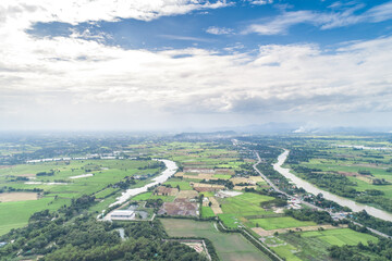 Obraz premium Top view of the Sakae Krang River, Uthai Thani Province where both sides of river are filled with lush green trees. There are community near waterside.