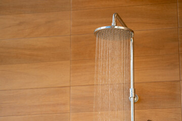 Outdoor shower head for the bath and showering cold water to body before jumping in the resort pool.