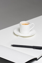 Business meeting setup with notebook and coffee cup on a clean office desk ready for note-taking tasks