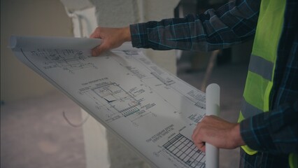 Caucasian man architect holding draft plan builder handyman work. The inscription plan of...