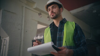 Serious Caucasian male engineer mechanic builder man writing tablet foreman guy planning draft...