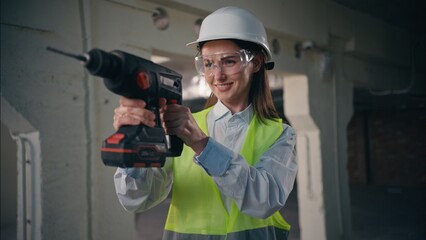 Confident professional Caucasian woman holding electric drill drilling using equipment female girl...