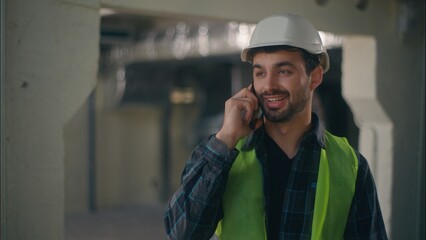 Cheerful Caucasian employee man handyman workman guy builder speaking conversation mobile phone in...