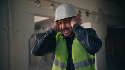 Caucasian builder worker man guy male handyman engineer architect in hardhat employee closing ears...