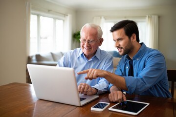 Multigenerational Learning Young Man Teaching Senior Citizen How to Use Computer Technology