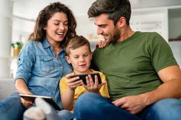 Happy technology addicted family parents and kid use laptop phone digital tablet at home,