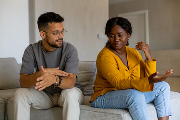 Couple fighting at home sitting on the sofa.