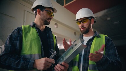 Caucasian men guys builders engineers talking discussing work repair in construction manufactory...