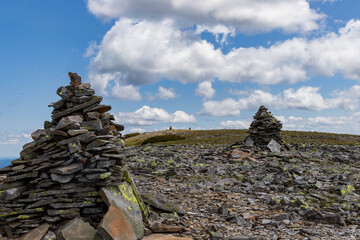 stones stacked in pyramids on top of a mountain against the sky