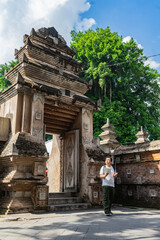 Asian man enjoying a joyful walk through the heritage streets of Kotagede. Old city exploration,...
