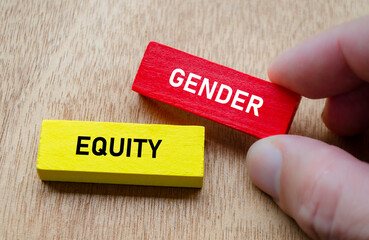 Gender equity shown by hand holding red and yellow wooden blocks. Diversity and inclusion concept