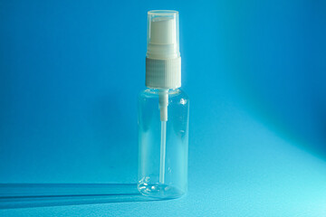Clear plastic spray bottle, simple design, against a vibrant blue backdrop.