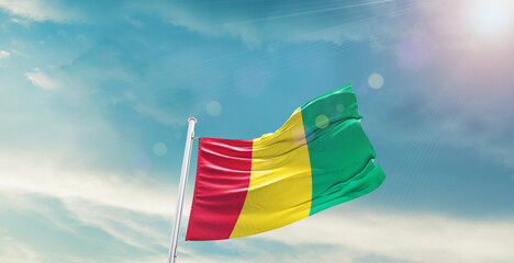 Guinea national flag waving with beautiful sky.