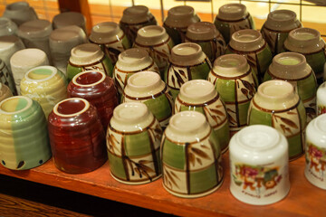A collection of ceramic cups displayed upside down, featuring various colors and patterns.