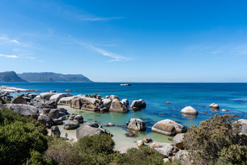 Sonniger Blick auf Boulders Beach mit einzigartigen Granitfelsen und klarem türkisfarbenem Wasser