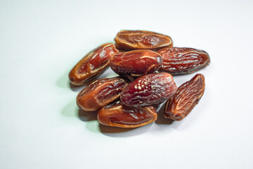 Close-up view of several brown dates arranged against a white background.