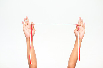 Hands holding a red and white ribbon, symbolising Independence Day for Indonesia or Poland on a...